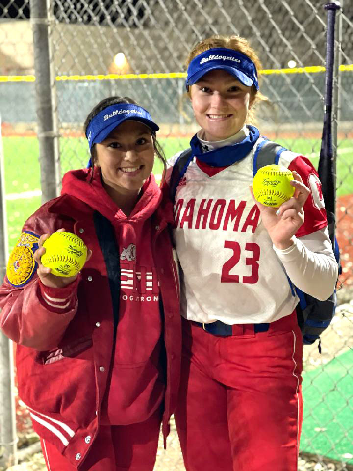 Girls holding softballs